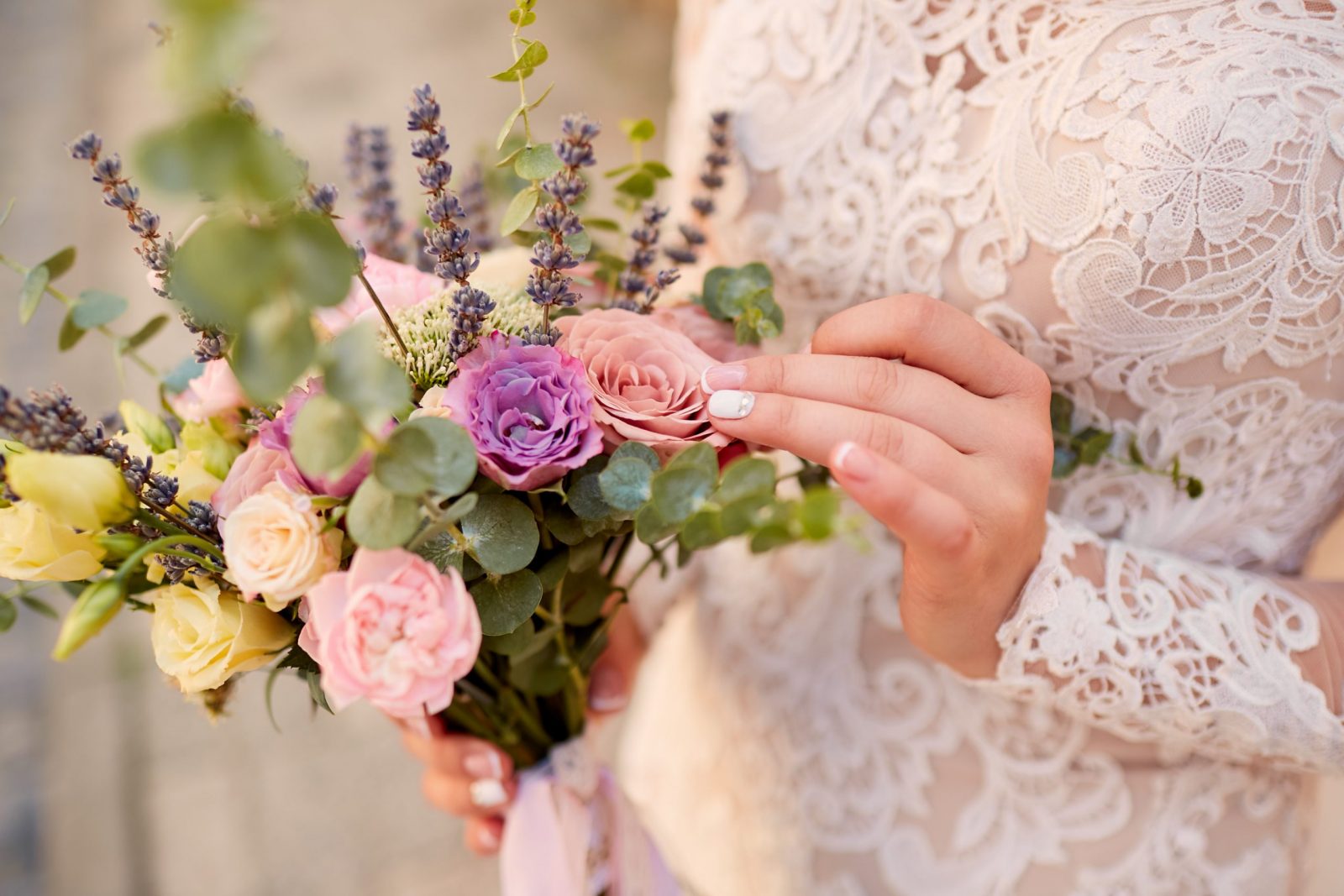 Close-up of pink and violet wedding bouquet in bride's hands